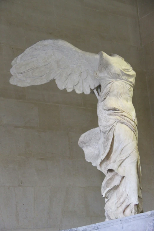 an angel statue with long wings in a room