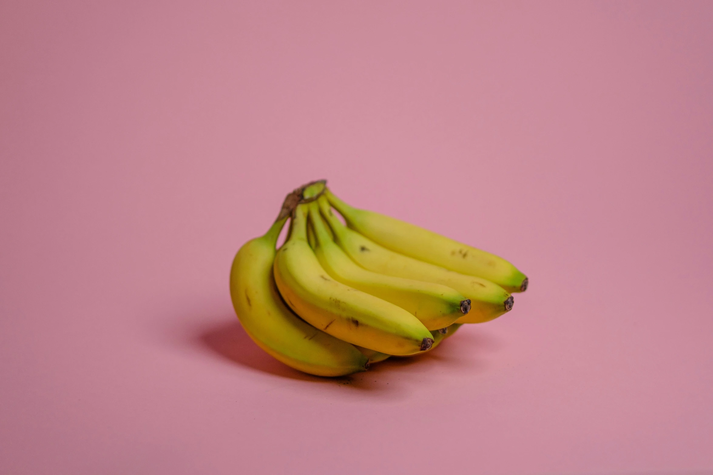a pile of ripe bananas sitting on top of a pink table