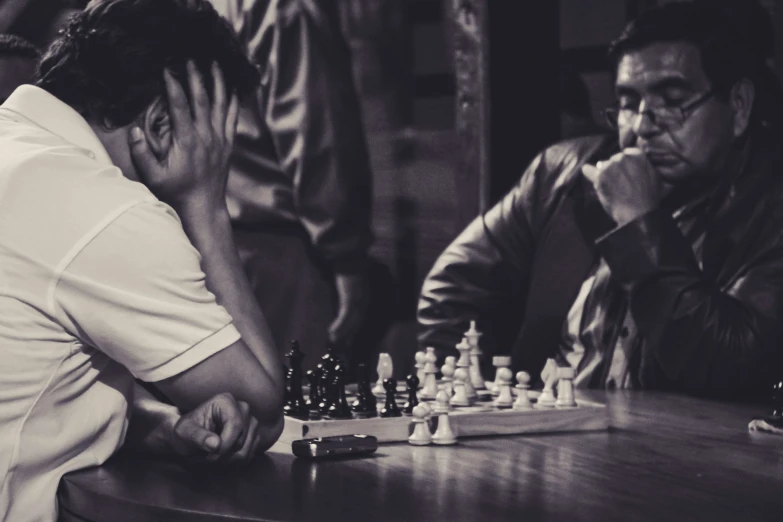 black and white pograph of man playing chess