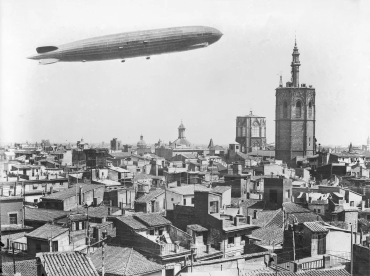 an old po shows a large airplane flying above buildings