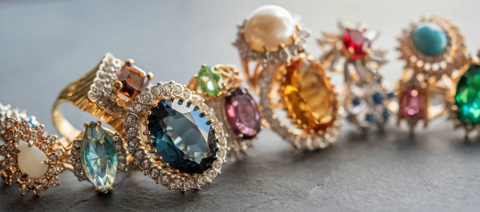 a row of rings with multicolored stone and pearl