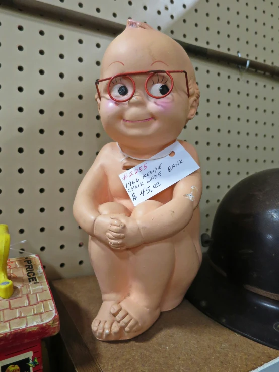 a brown statue with glasses and a note