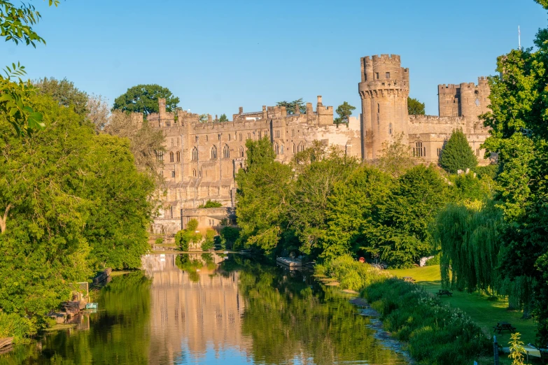 a castle surrounded by trees and water in a park