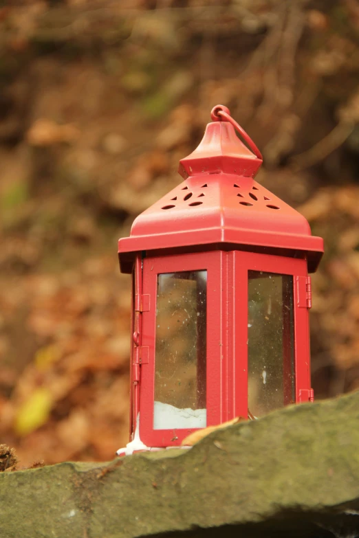 a small red lantern is sitting on a rock