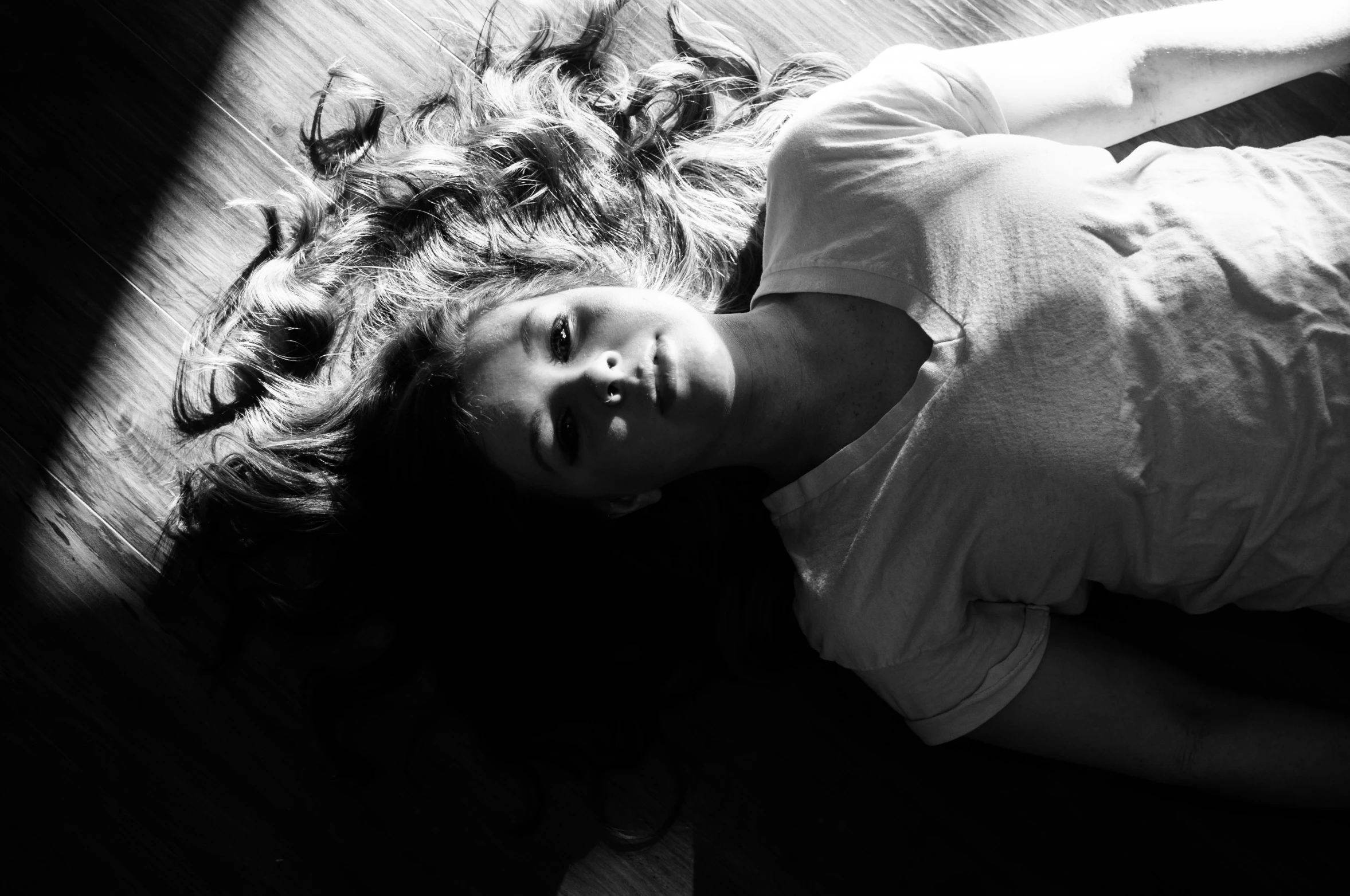 a little girl laying on the floor in front of a camera