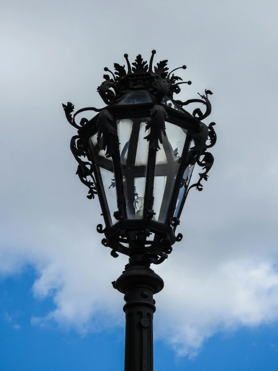 a street light in front of a cloudy blue sky