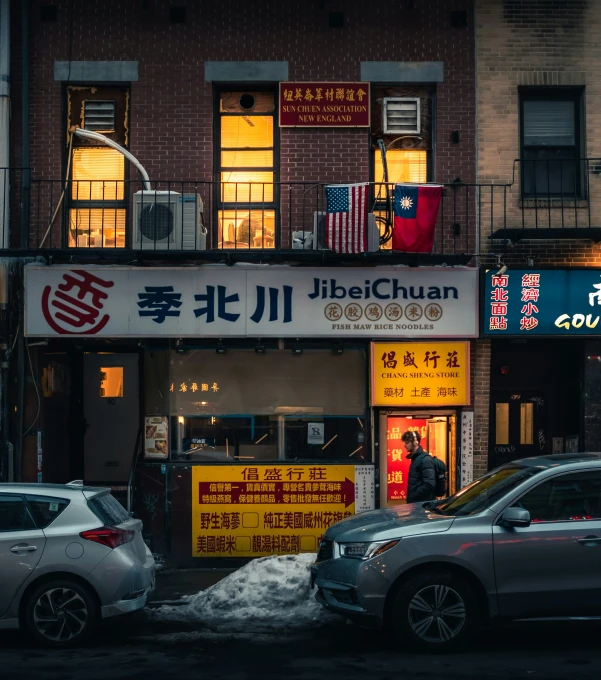 the street is blocked off with snow as a restaurant has it's name written in mandarin, and its name is japanese