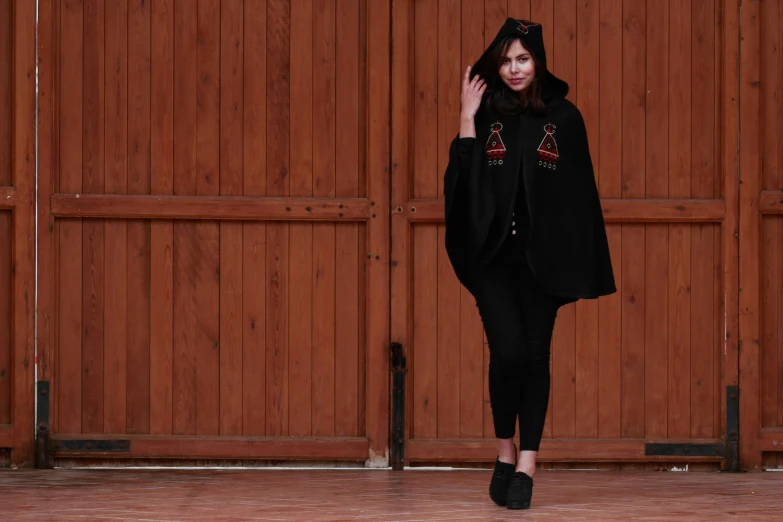 a woman in black walks down a wooden floor