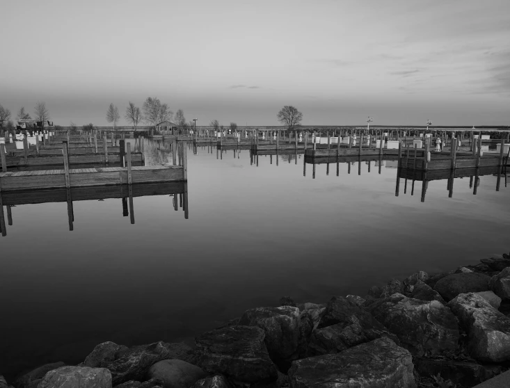 black and white pograph of water and wooden docks