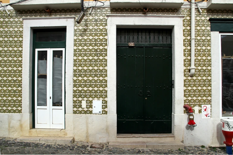 a building with two green doors and a clock