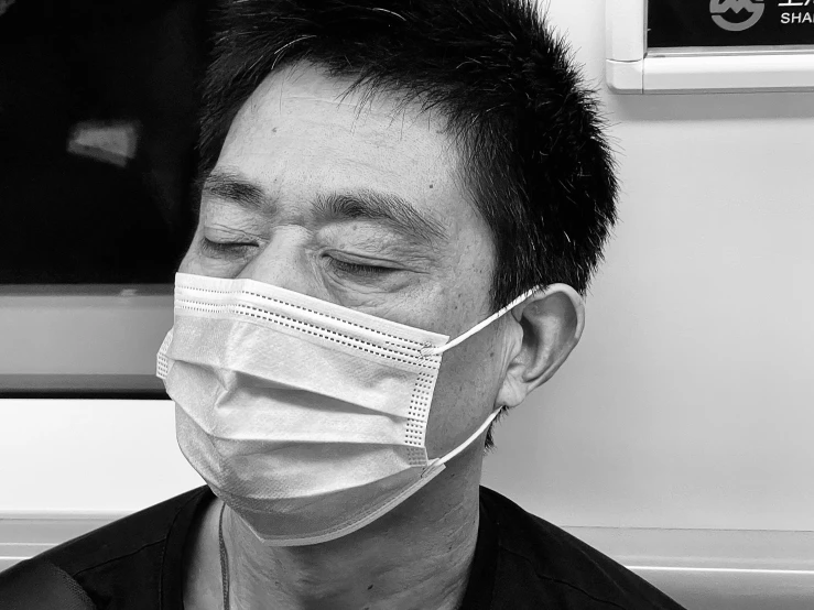 a man wearing a face mask stares away from the camera