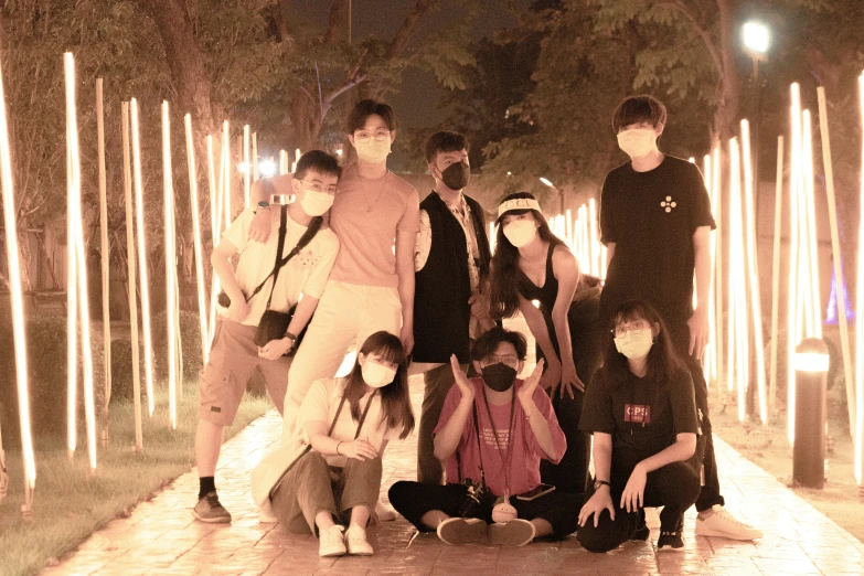 the group of people posing for a picture in front of candles