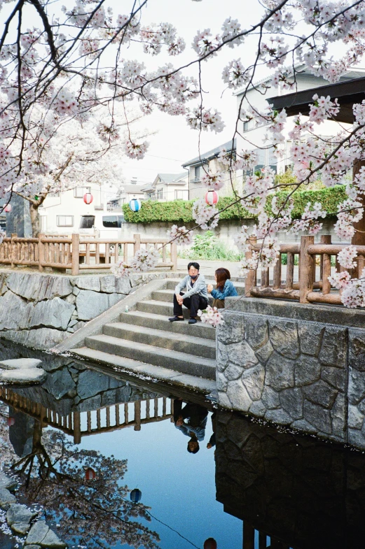 people are sitting on stairs in the japanese garden