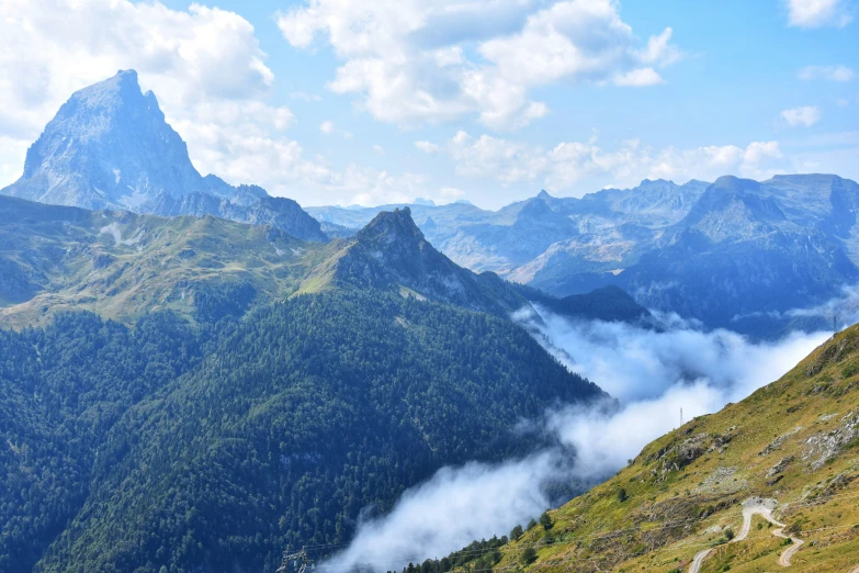 a mountain scene with mountains and clouds, and a horse