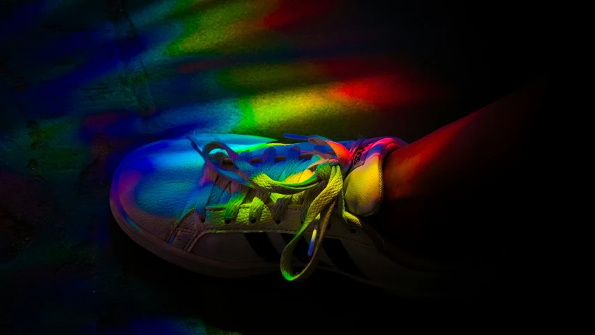 a tennis shoe with rainbow stripes on the shoe
