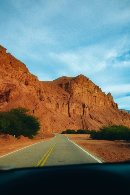 a car is sitting in the road with mountains in the background