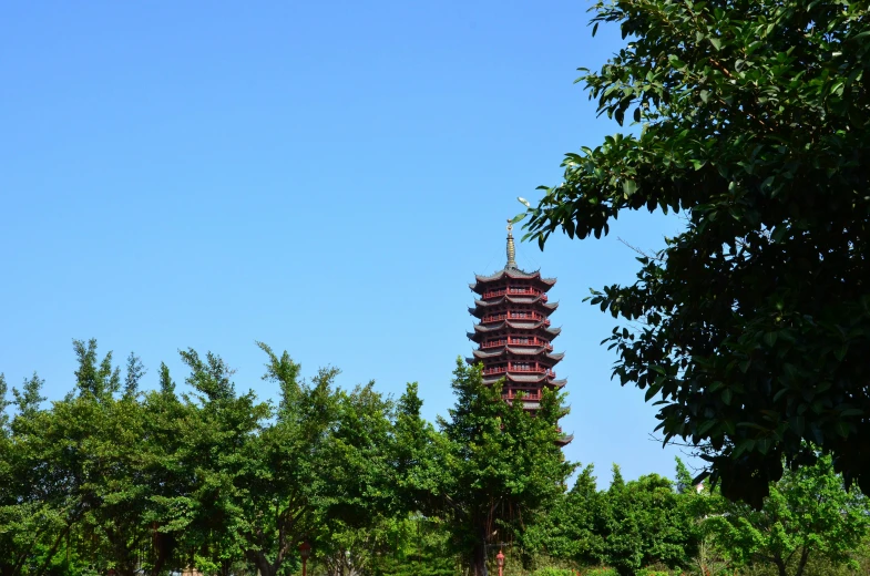 a tall pagoda stands next to some trees