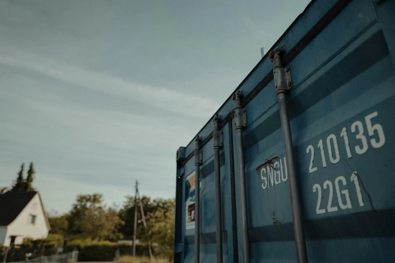 some blue dumpster next to a building with the year 2013 on it