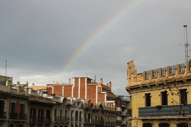 a rainbow is shining in the sky above a building