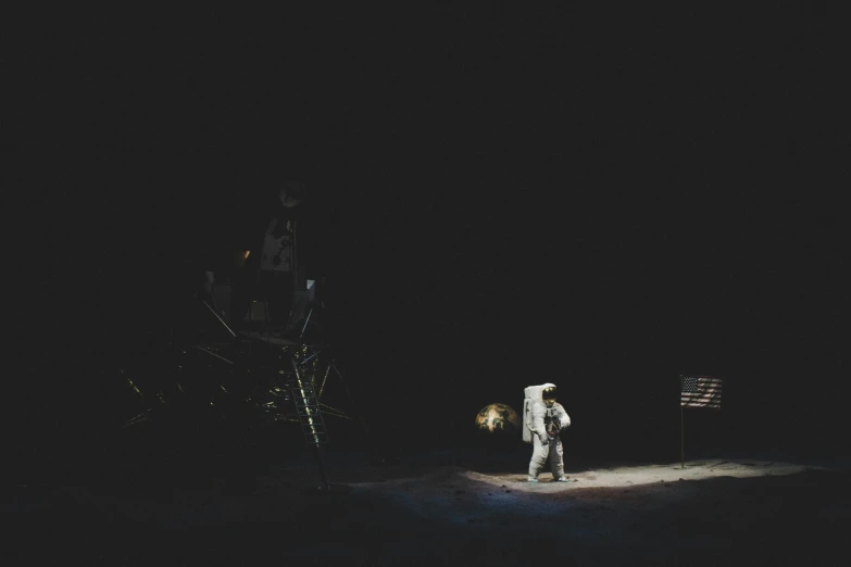 an astronaut walks in the dark with his arm over his face