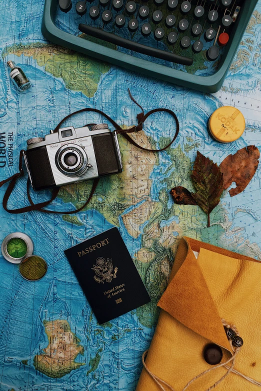 a map, a camera, a passport, and a typewriter with two other items in front