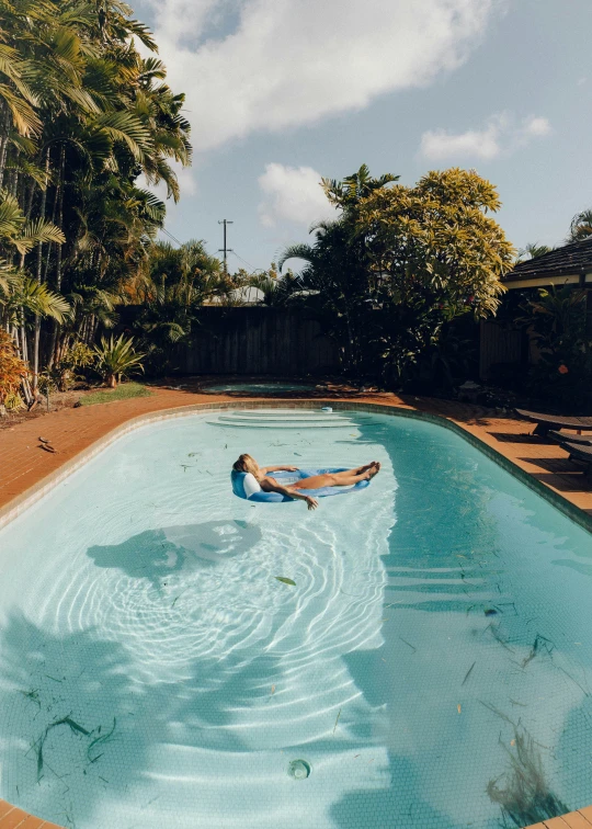 a woman is lounging on her back in a pool