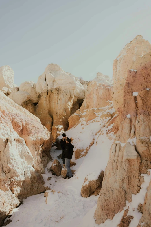 a couple of men are walking through some snow