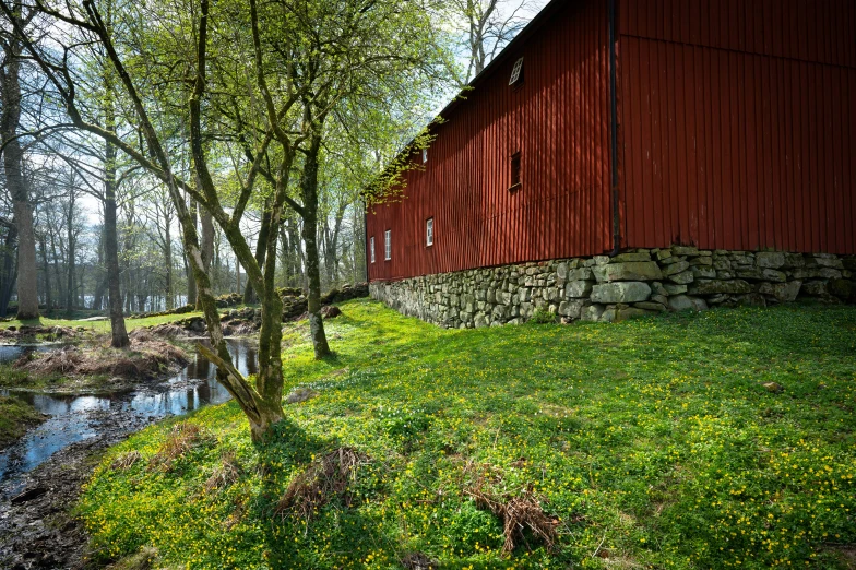 a red barn and some water on the grass