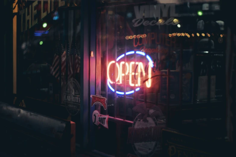 the neon sign is glowing in front of a store