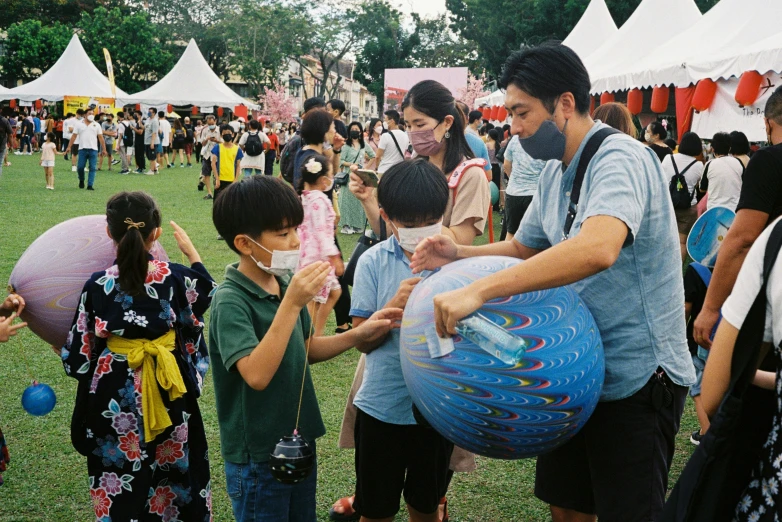 group of people standing around an inflatable ball