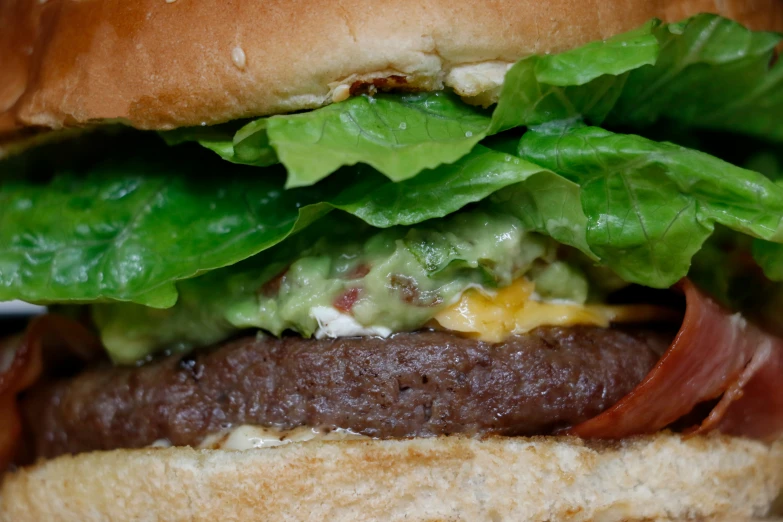 a hamburger with meat, lettuce and cheese