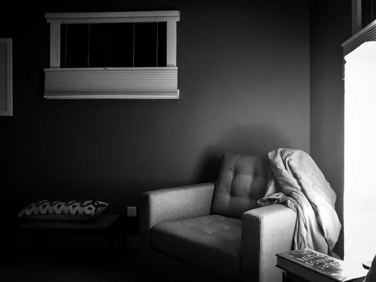 a chair sitting in front of a window under a blanket