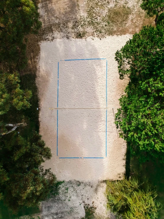 an aerial view of a tennis court surrounded by trees