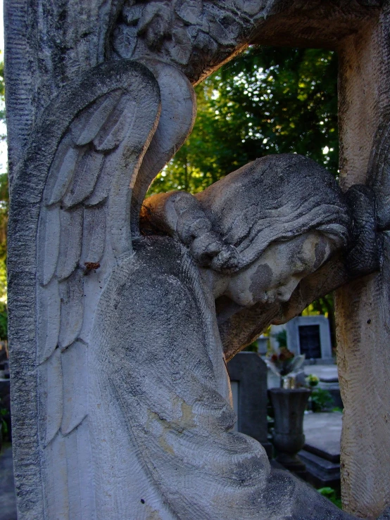 a statue of an angel and a cross on a cemetery