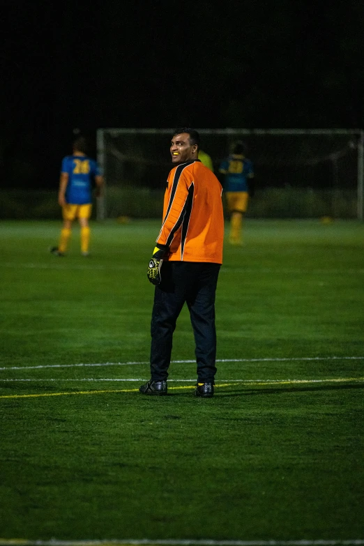 the man is standing on the soccer field