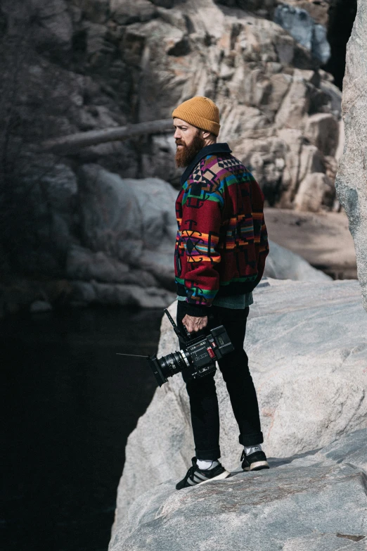 the man is standing on top of a large boulder