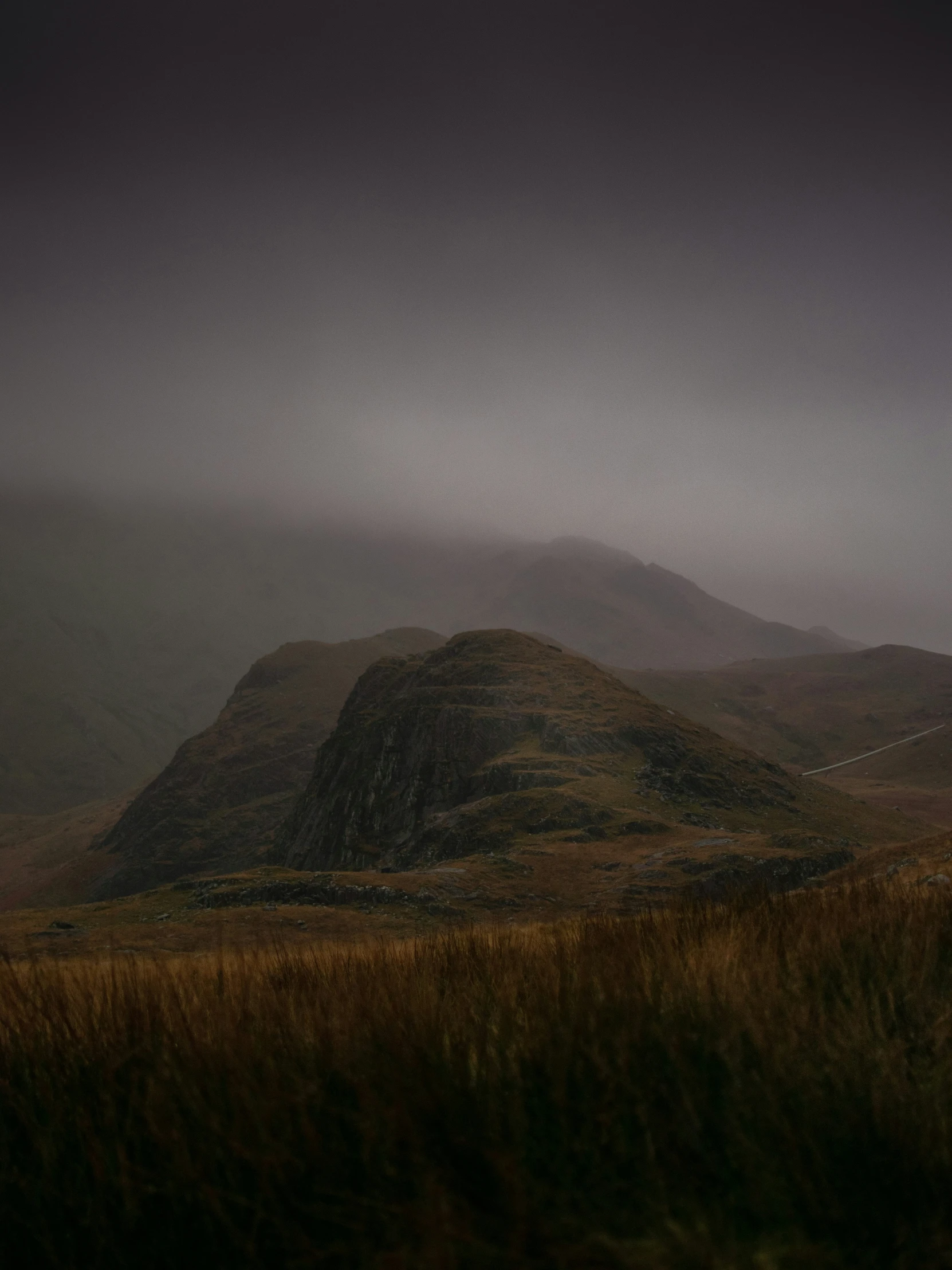 the mountain landscape is covered in dark, fog