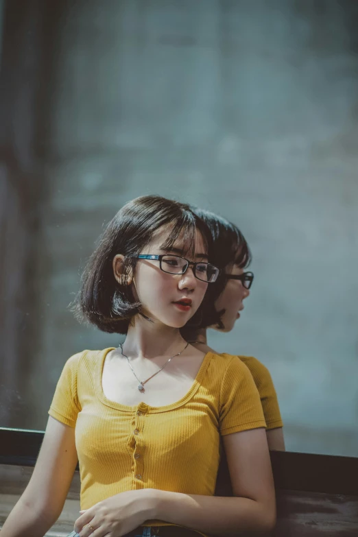 a woman in a yellow shirt sitting next to another person