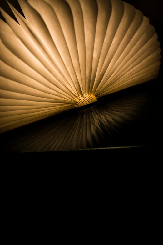 the folded book in the dark has a shadow on the table