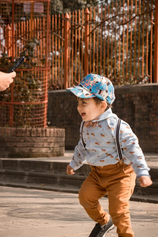 the young child is walking with a smart phone