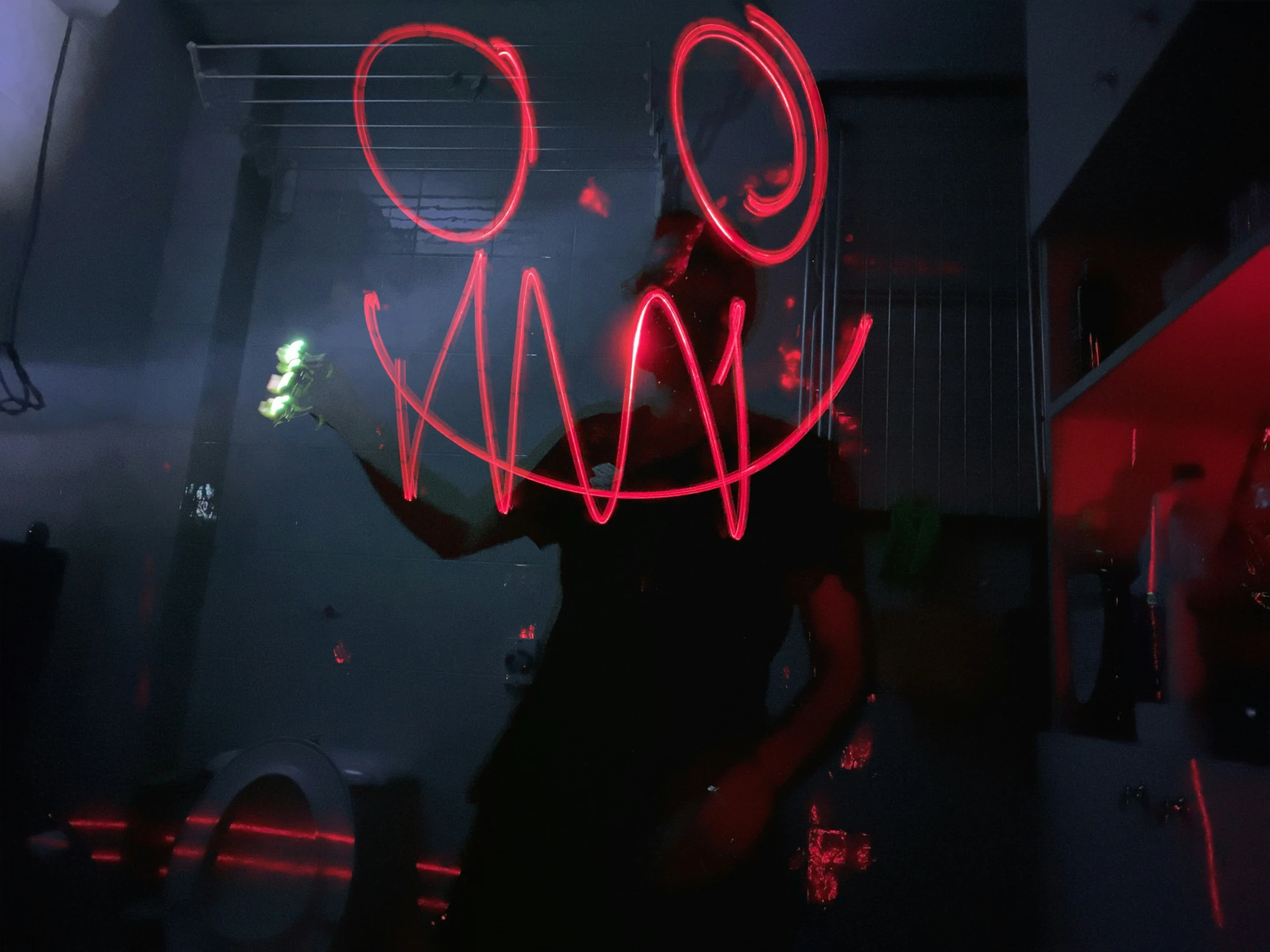 a person is standing in the dark holding a neon object