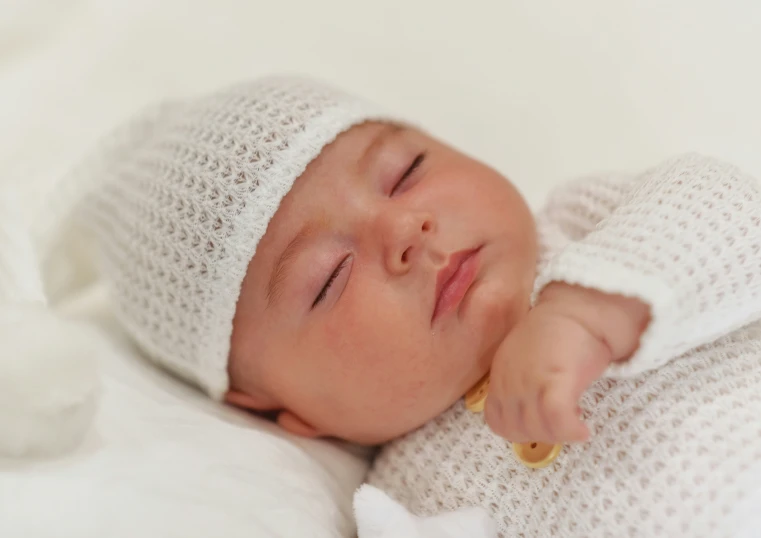 a small baby sleeping on a white blanket