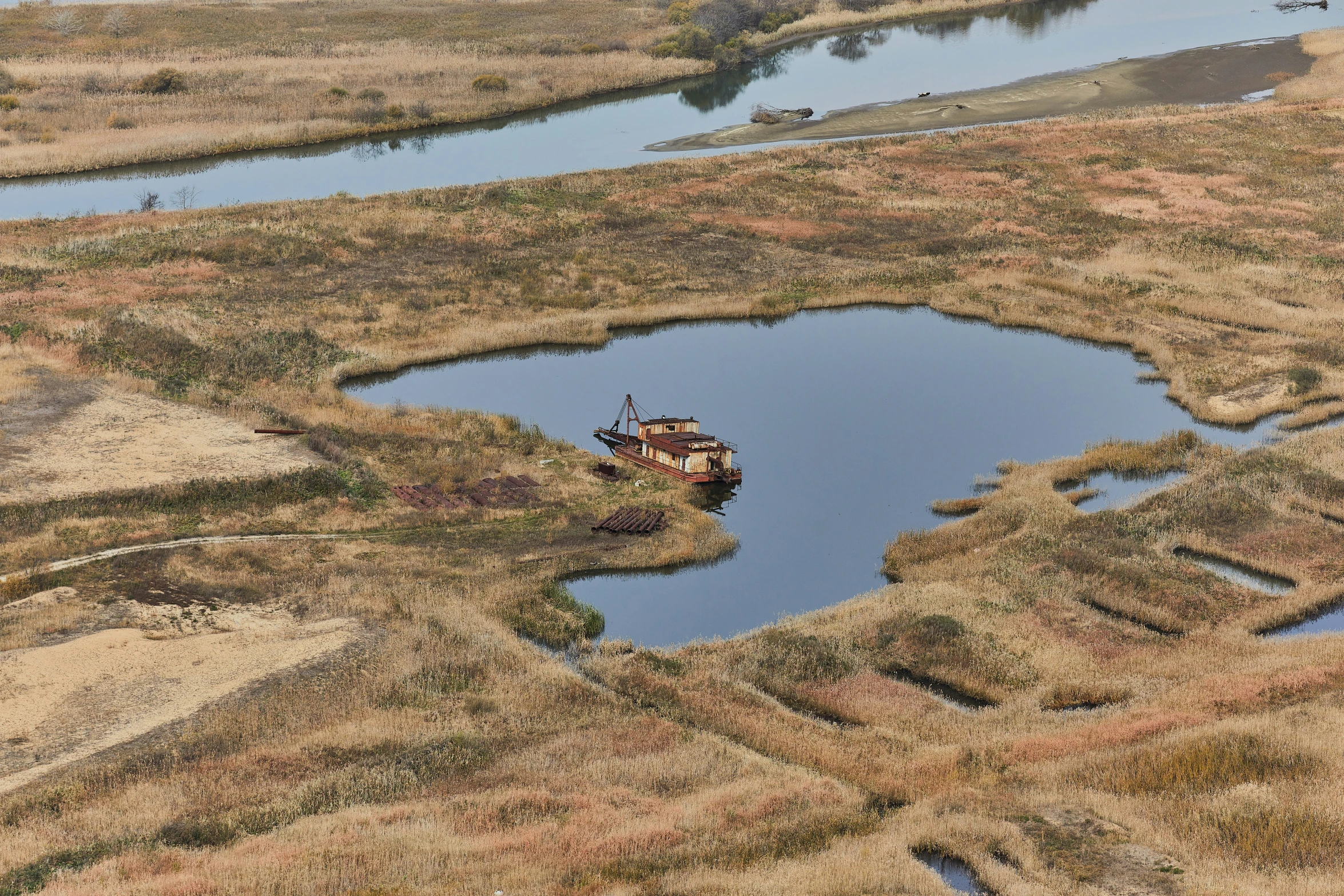 a small boat is sitting on land, with a few people nearby