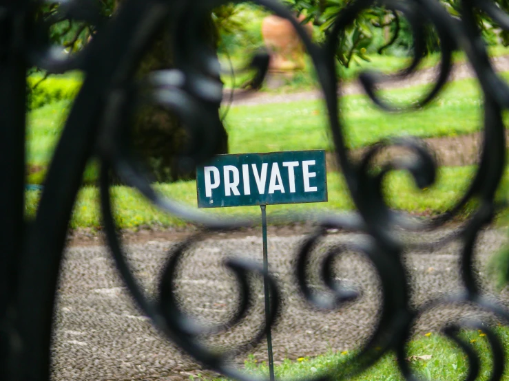 a sign posted through the iron bars to indicate private