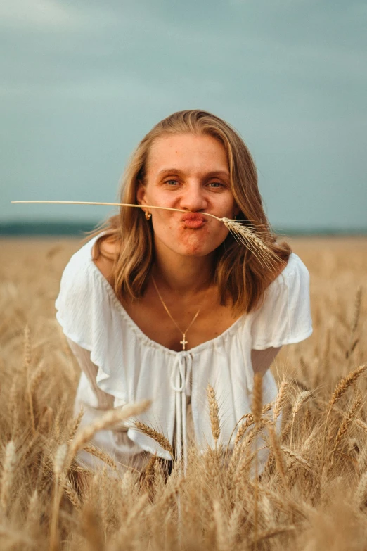 woman sitting in field blowing bubbles in the air