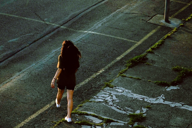 a woman is walking down the side walk