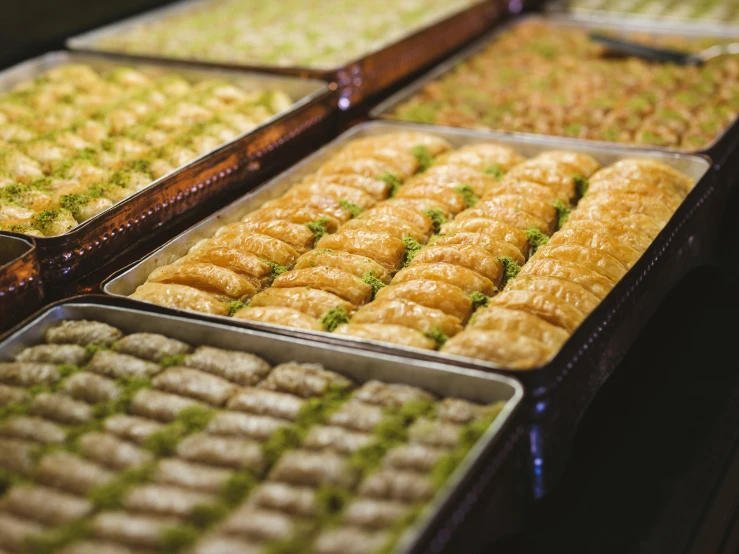 many trays of pastries in different varieties