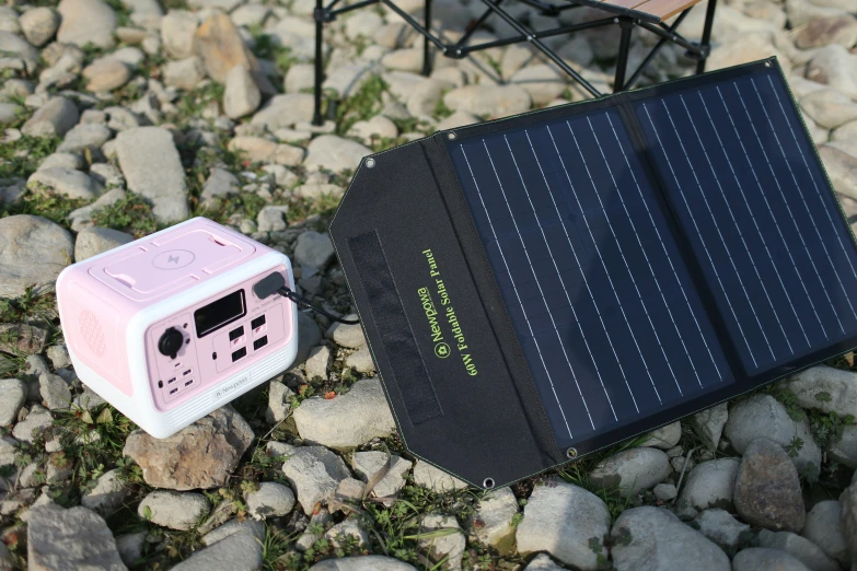 a pink solar panel next to a remote control