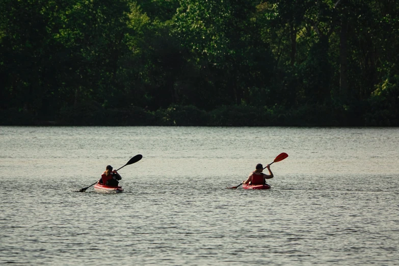two people are kayaking along the water together