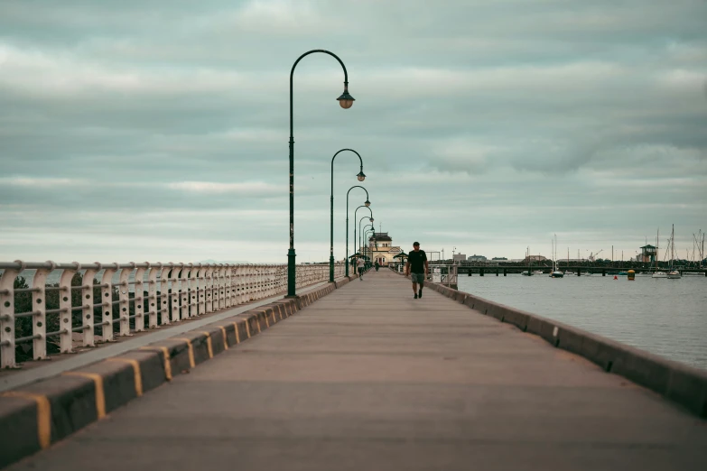 a man walks along the end of a wooden bridge